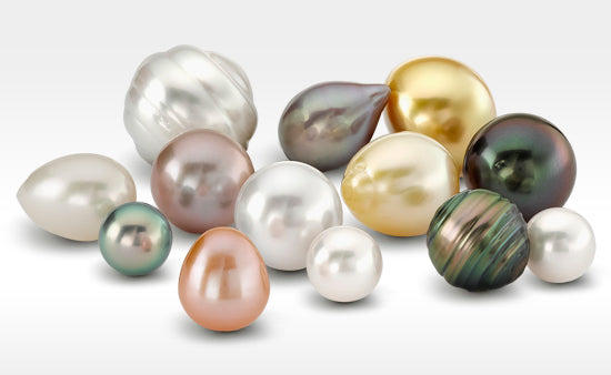 Assorted pearls of various colors on a light gray background