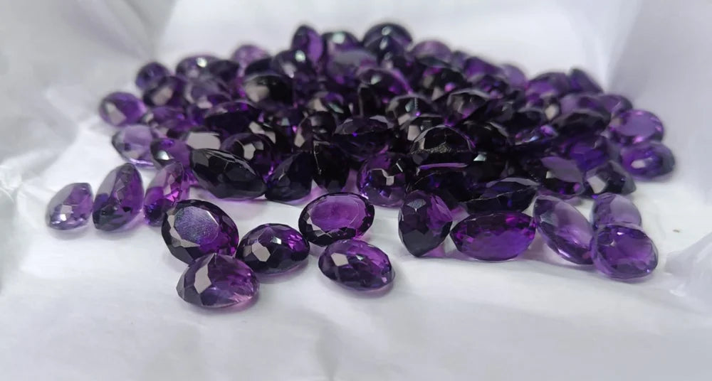 Purple Amethyst gemstones on a white fabric background