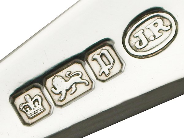 Silver bar with stamped hallmark symbols including a crown, lion, and 'J.R.'