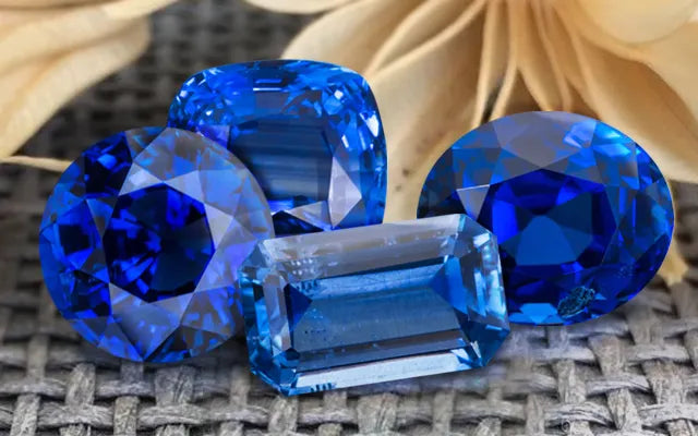 Four blue sapphires gemstones on a textured surface