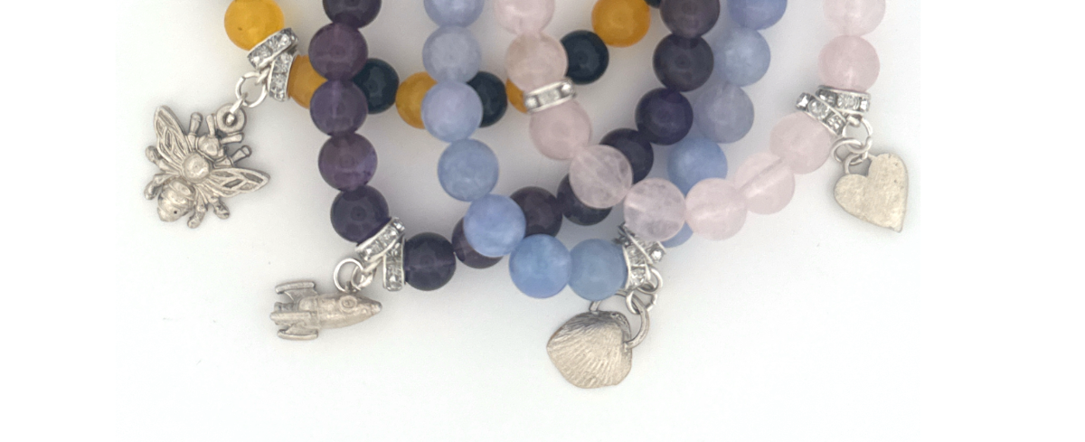 Set of beaded bracelets with charms on a white background