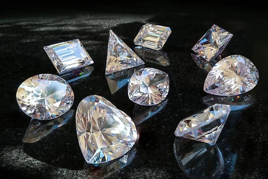 Loose diamonds on and dark marble surface.