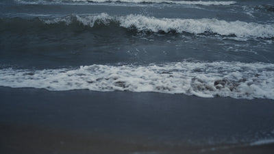 video of seawaves coming into the beach on a dull day.