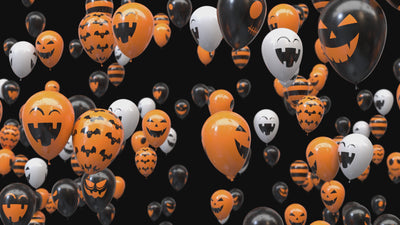 video of many black, orange and white balloons with painted halloween designs. the balloons are continuously flying from the bottom to the top.