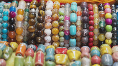 video moving right to left showing many types and colours of stringed beads presented next to each others.