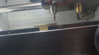 close up video of the Redt Turbo-C3 stamp making machine in action. Video shows a brass block being milled with a small drill.